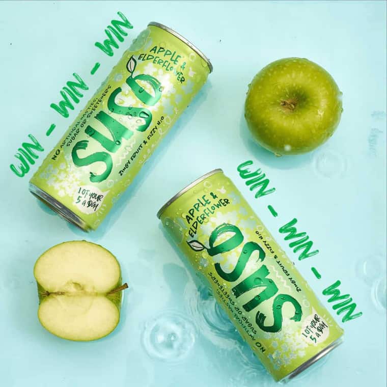Suso Apple & Elderflower cans next to fresh apples